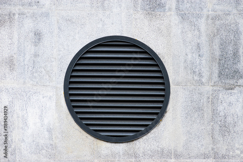 round ventilation grille on a concrete wall