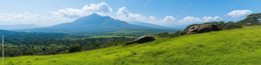 A mountain range is visible in the distance with a large rock on the hillside. The sky is clear and blue, and the grass is lush and green. Concept of tranquility and natural beauty A mountain range is visible in the distance with a large rock on the hillside. The sky is clear and blue, and the grass is lush and green. Concept of tranquility and natural beauty