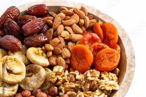 Mixed nuts and dried fruits on a plate on a white background, copy space. Symbols of the Jewish holiday of Tu Bishvat Healthy snack photo