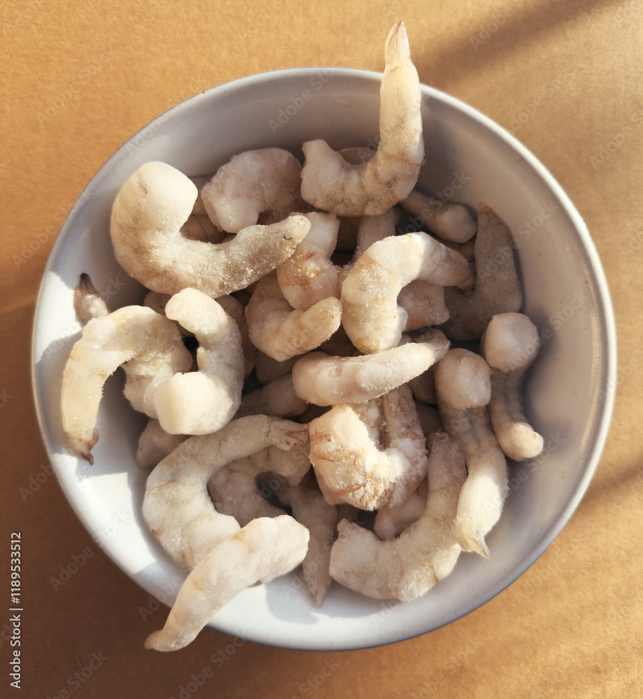 Overhead shot of frozen raw king prawns, defrosting in a bowl. Overhead shot of frozen raw king prawns, defrosting in a bowl.