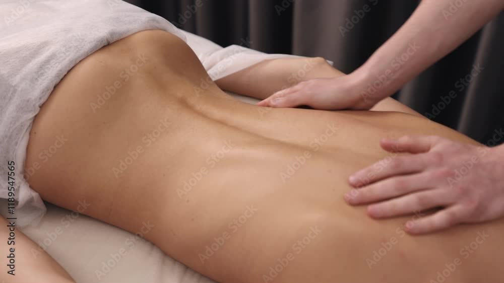 Deep tissue, client relaxation, body massage. On massage table, therapist performs back massage aimed at promoting relaxation and providing muscle relief to client. Deep tissue, client relaxation, body massage. On massage table, therapist performs back massage aimed at promoting relaxation and providing muscle relief to client.