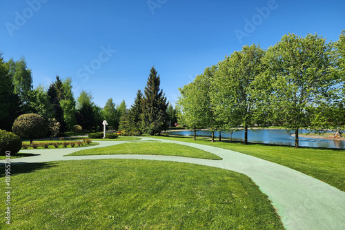 Wallpaper Mural A park area with picturesque landscaping and winding paths by a serene lake on a sunny .summer day. Torontodigital.ca