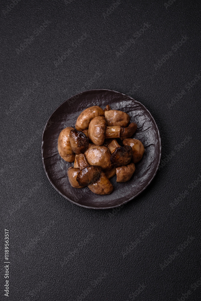 Obraz premium Grilled champignon mushrooms with salt, spices and herbs