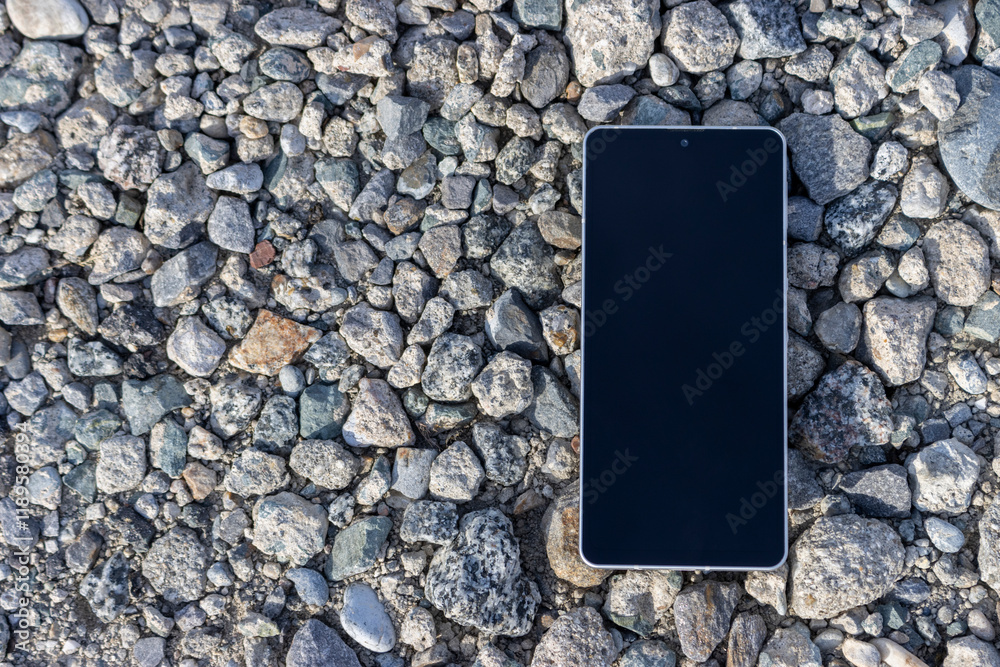 小石の道に落ちたスマートフォン