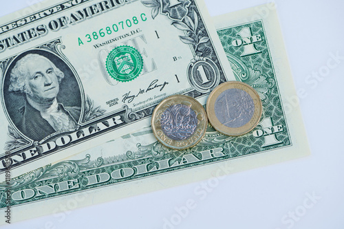 Currency display includes a single dollar bill, one pound coin and one Euro coin arranged neatly.