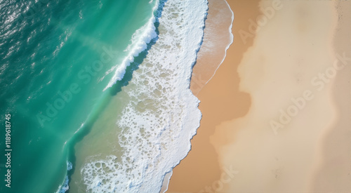 Turquoise ocean waves meet the golden sand. An aerial view captures the serene beauty of the coastline where the vibrant sea kisses the shore.