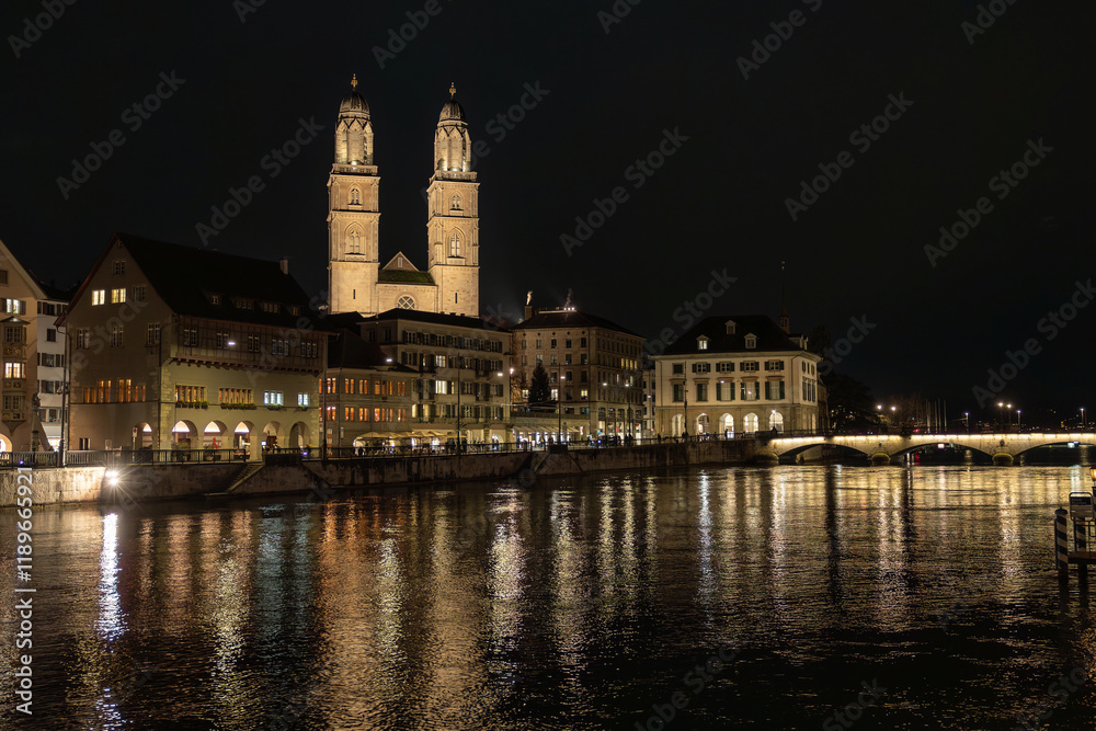 Nighttime View of Historic City Center with Illuminated Cathedral and Buildings in Zurich