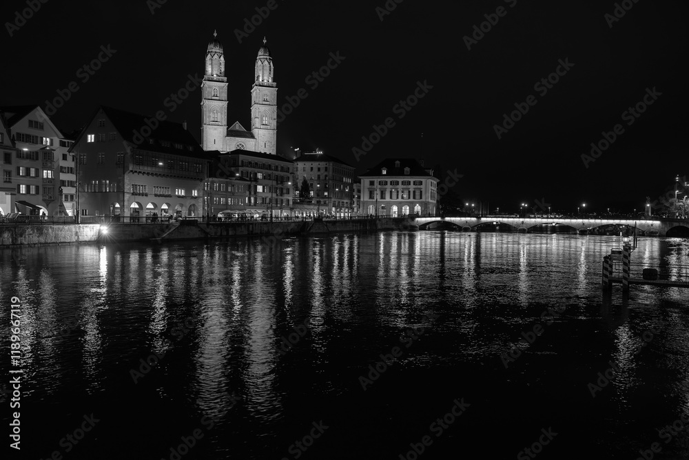 Fototapeta premium Nighttime View of Historic City Center with Illuminated Cathedral and Buildings in Zurich