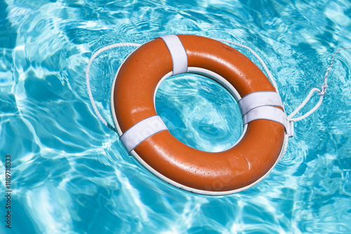 Safety equipment. Life buoy or rescue buoy floating on water. Ring for rescue. Help in water concept. Lifebelt on sea or pool. Orange inflatable ring floating in blue water. Life buoy for protect and