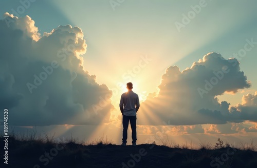 Silhouette of alone person looking at heaven. Lonely man standing in fantasy landscape with shining cloudy sky