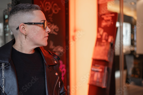 Lesbian woman wearing leather jacket and glasses showing masculinity photo