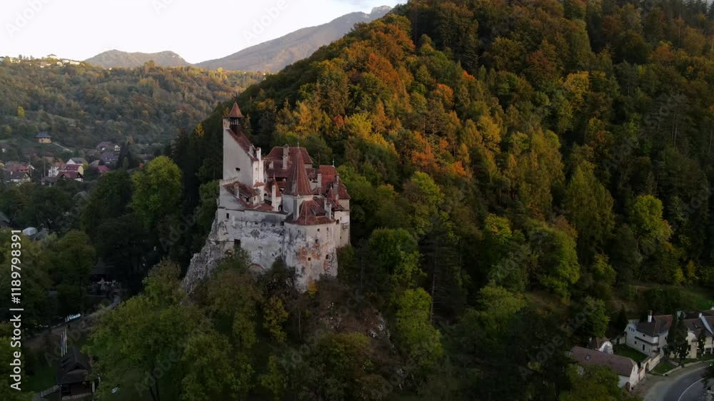 Aerial Panning Shot Of Famous Bran Castle On Green Hill In Residential Town Aerial Panning Shot Of Famous Bran Castle On Green Hill In Residential Town