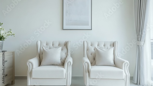 A white living room interior features elegant armchairs and a prominently displayed poster. photo