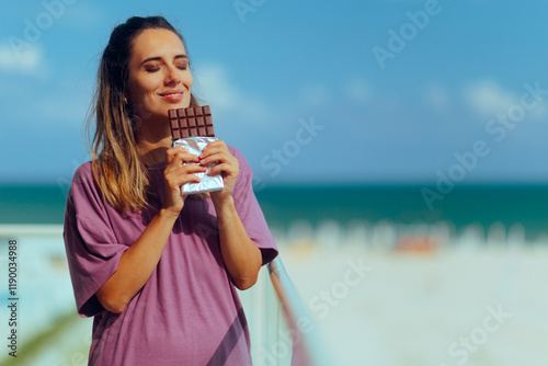 Bild auf Leinwand Woman Eating a Chocolate Bar in the Balcony
