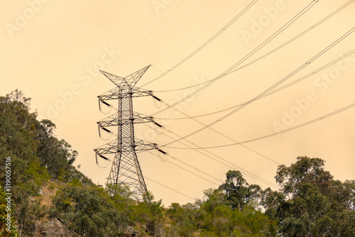 Photograph of a large electricity Transmission Tower on a grassy hill against an orange sunset sky in regional Australia. photo