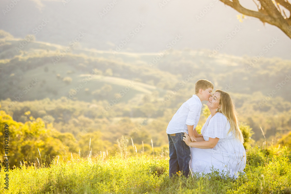 Mother and son embracing in intimate moment on hilltop Mother and son embracing in intimate moment on hilltop