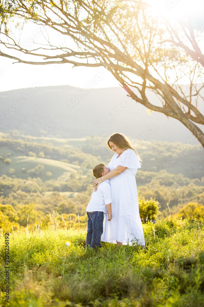 Mother and son embracing in intimate moment on hilltop Mother and son embracing in intimate moment on hilltop