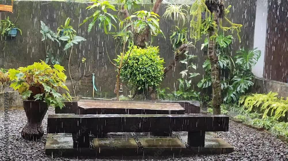 Rain atmosphere wets wooden tables and chairs in a cafe with a natural atmosphere. Caffe Angglo. Jember Indonesia.