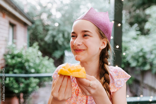 Young teenage girl enjoying a fresh ripe mango. photo