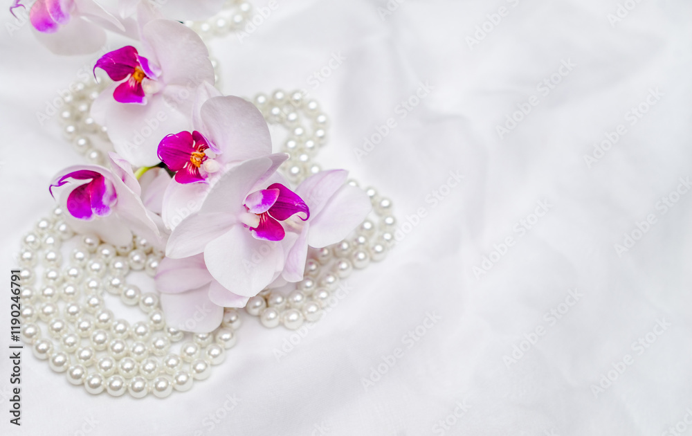 The branch of purple orchids on white fabric background
The branch of purple orchids on white fabric background