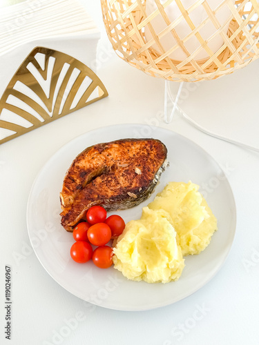 Grilled salmon with cherry tomatoes and mashed potatoes on a white plate photo