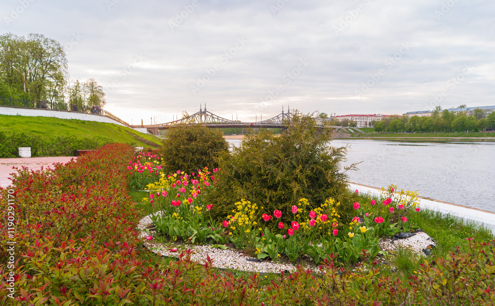 Φωτογραφία Flower bed with tulips on the Volga River embankment with a view of the Old Volga Bridge