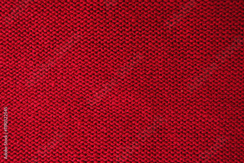 Wool fabric laid out flat in stockinette stitch. A close-up of the back of a sweater knitted in stockinette stitch in bright red yarn. Textile patterns: a background of knitted rows. photo