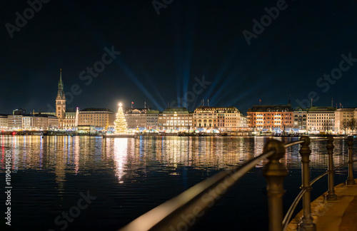 Beleuchtete Fassaden der Häuser an der Binnenalster von Hamburg während der Weihnachtszeit am Abend, beleuchtete Stände vom Weihnachtsmarkt, Märchenschiffe und ein beleuchteter Tannenbaum auf der Alst photo