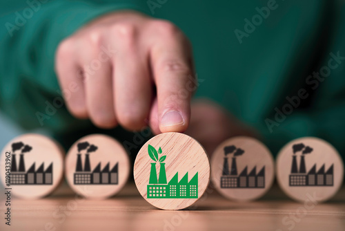 Hand pushing green factory to in front of pollution manufacturing for green economy to reduce carbon dioxide emission from Kyoto protocol within 2050 ,Sustainability environment concept. photo