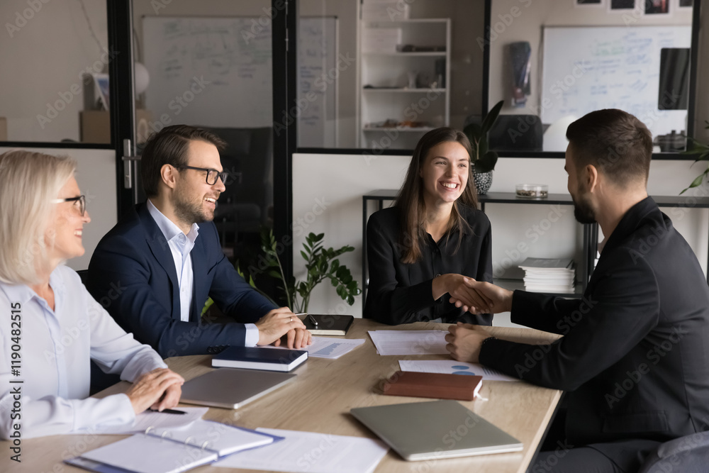 © fizkes - Two business partners shaking hands in conference room at table during group meeting with project colleagues or managers, closing profitable deal, signing contract, discuss investment, launch startup © fizkes - Two business partners shaking hands in conference room at table during group meeting with project colleagues or managers, closing profitable deal, signing contract, discuss investment, launch startup