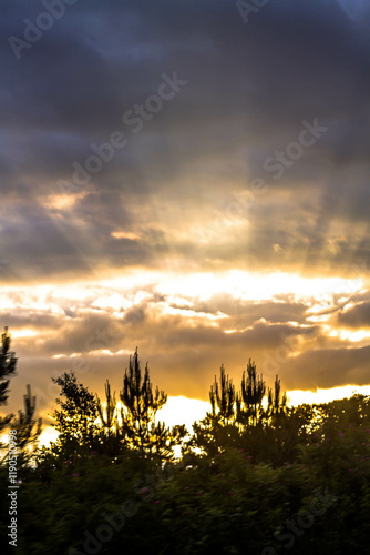 Sunset behind the clouds in the sky. Beautiful nature background.