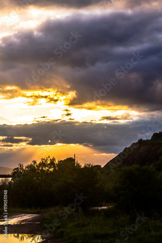 Sunset behind the clouds in the sky. Beautiful nature background.