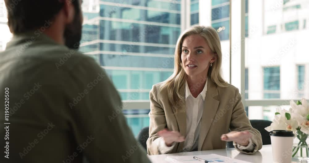 Happy confident blonde business leader woman talking to partner, job candidate, colleague man, speaking with hands moving, sitting at office meeting table, shaking hands with male coworker