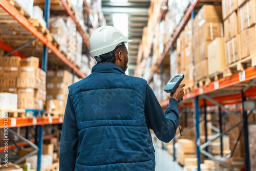 Rear view of an african worker scanning packages at warehouse