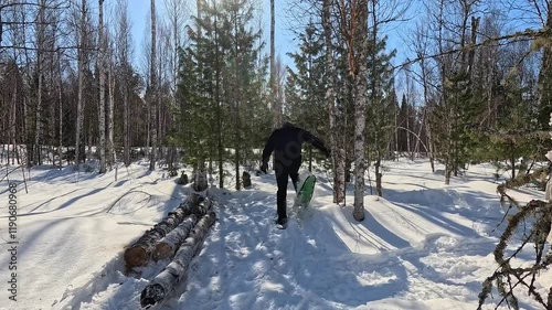 Walking through a winter forest in snowshoes. A man in snowshoes walks through a winter forest. Trampling snow with snowshoes. A MAN prepares a winter camp.