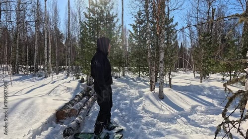 Walking through a winter forest in snowshoes. A man in snowshoes walks through a winter forest. Trampling snow with snowshoes. A MAN prepares a winter camp.