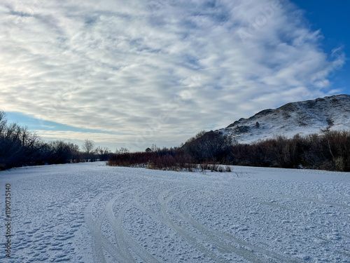 winter in the mountains. Frozen river ice surface. Hudag Mountain  photo