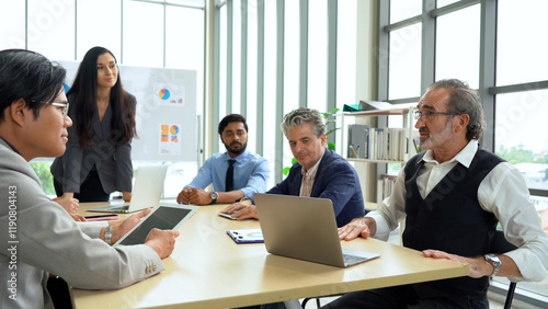 serious senior business manager man talking or debate to colleagues in meeting on table with data in office. angry leader presentation explain and answer questions coworker