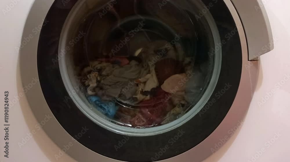 automatic washing machine, laundry is dying, black hatch, drum is spinning automatic washing machine, laundry is dying, black hatch, drum is spinning
