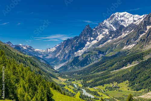 Val Ferret mountain landscape in the Alps. Beautiful alpine scenery of the high mountain summits and green valley in summer under blue sky at sunny weather om Tour du Montblanc
