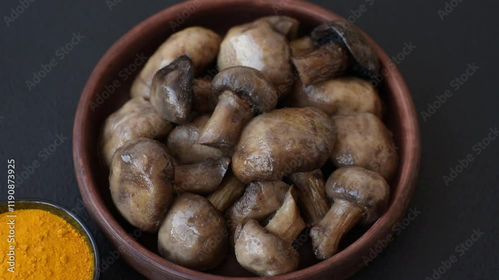 Grilled champignon mushrooms with salt, spices and herbs on dark concrete background Grilled champignon mushrooms with salt, spices and herbs on dark concrete background