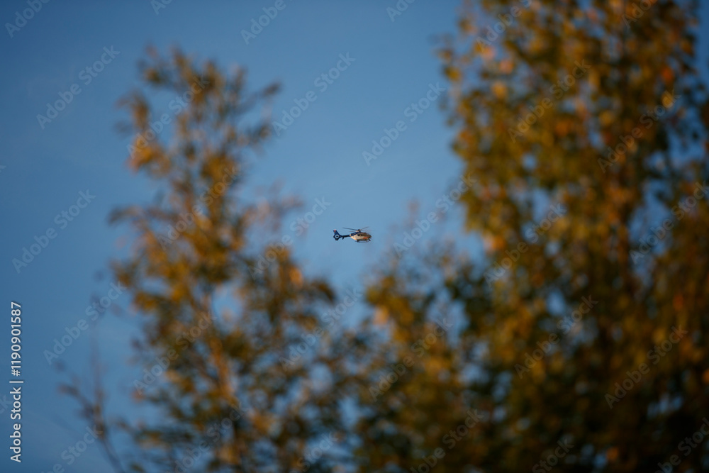 Police Helicopter flying above trees during sunset in a tranquil outdoor setting Police Helicopter flying above trees during sunset in a tranquil outdoor setting
