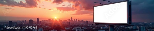 A blank billboard against a stunning sunset over an urban skyline.