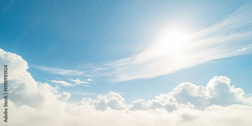 Fototapeta premium Bright sun shining over fluffy white clouds in clear blue sky