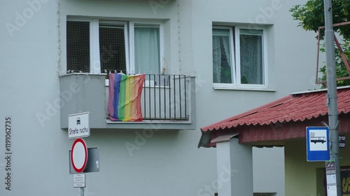 LGBT rainbow flag hangs on railing of outdoor balcony in Polish city. Supporting sexual minorities and human diversity during Pride Month.