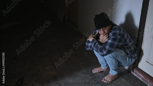 A drug addict is hallucinating from drug use in an abandoned building.