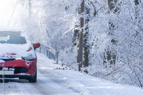 Car on a winter road through a snow covered forest photo