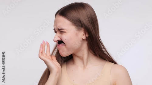 A girl removes her moustache with wax strips. A procedure for removing hair on a woman's body.A girl removes her moustache with wax strips. A procedure for removing hair on a woman's body.