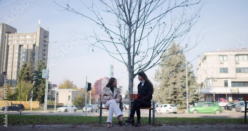 Wallpaper Mural Two Young Women Chatting on a Bench in an Urban Park on an Autumn Day Torontodigital.ca