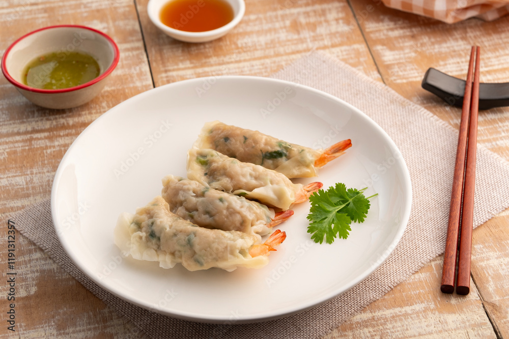 Thai boiled Wonton wrapped with shrimp and minced pork in white plate.appetizer food Thai boiled Wonton wrapped with shrimp and minced pork in white plate.appetizer food